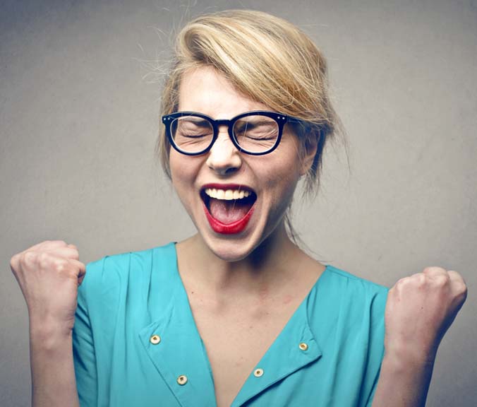 woman with glasses happy with fists clenched screaming with joy after quitting smoking
