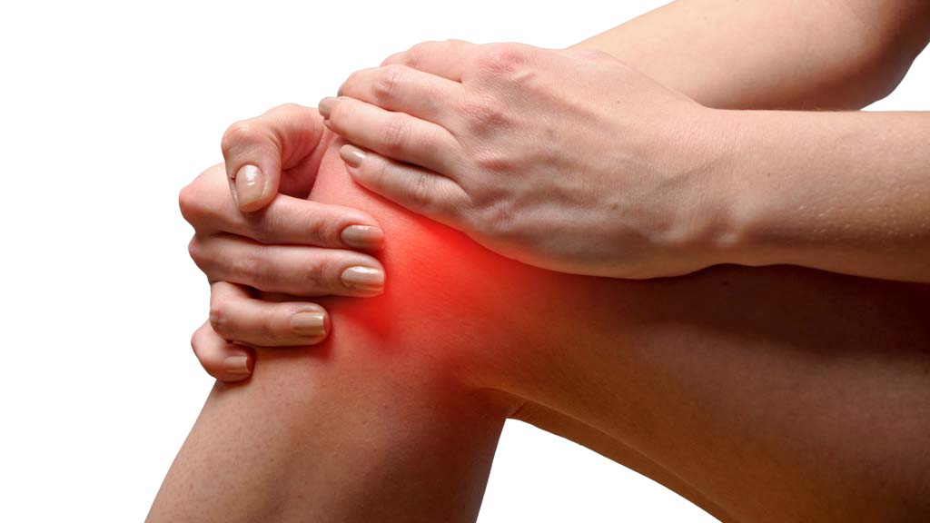 woman holding knee that is radiating with pain