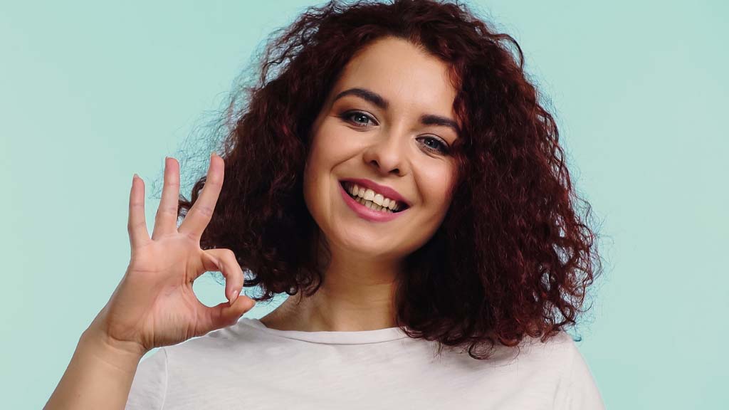 woman saying "ok" with fingers on her right hand - smiling about safe laser therapy