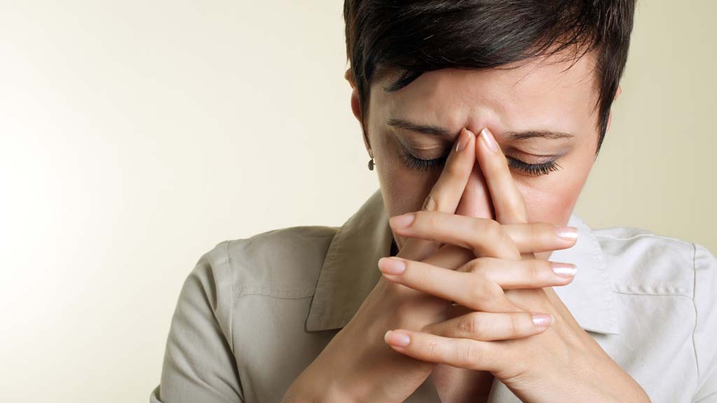 woman with hands on her face showing depression nd stress